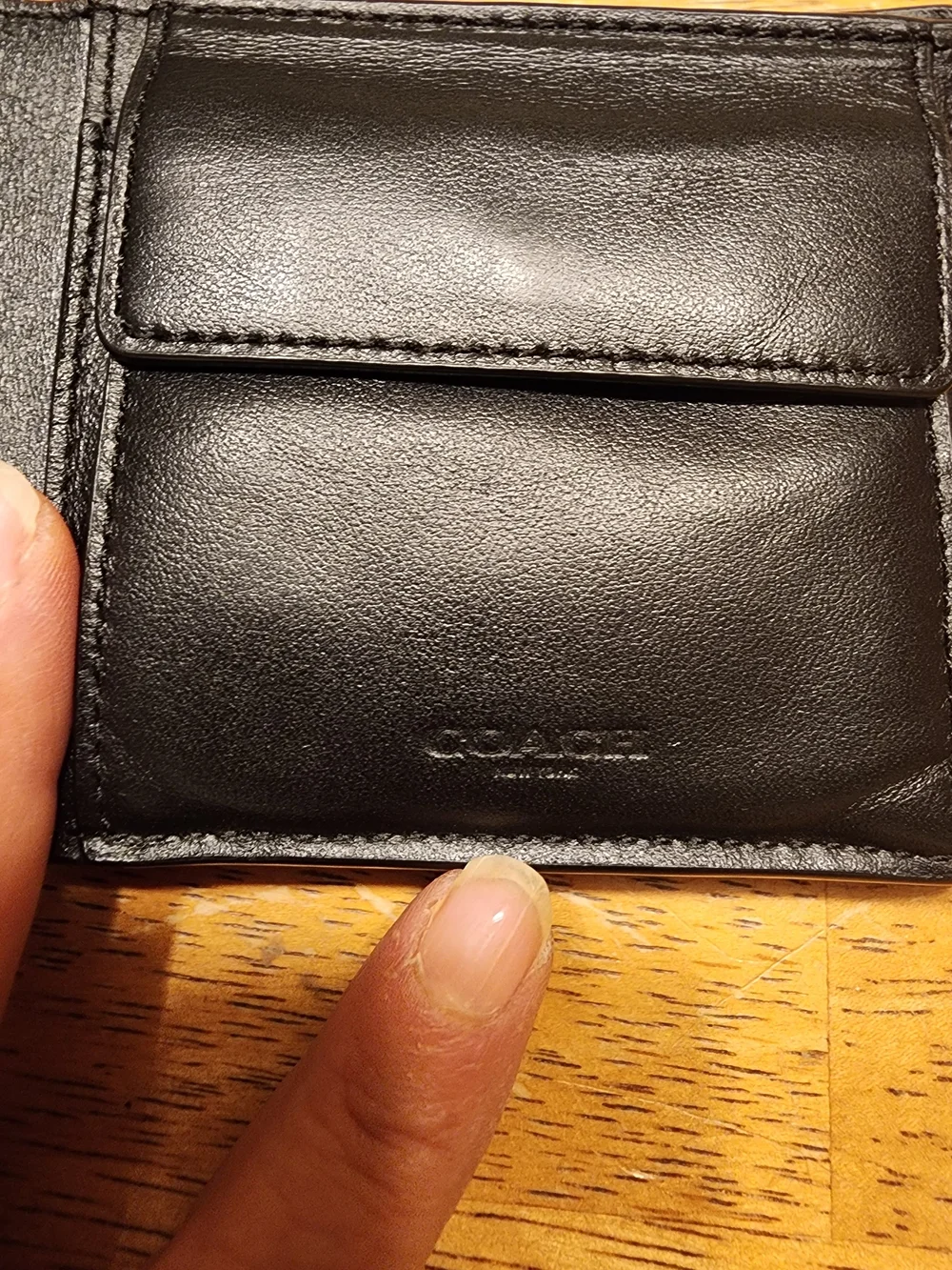 black Coach 3-in-1 wallet featuring the brand's iconic debossed signature pebble